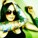 Beautiful girl with stylish make-up and tattooed arms..